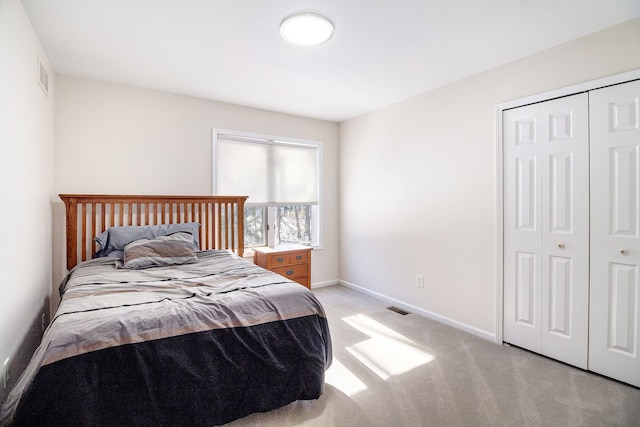 bedroom featuring light colored carpet and a closet