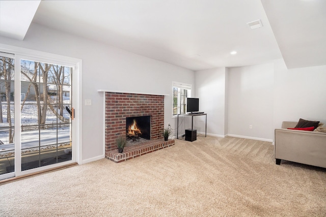 living room featuring light carpet, a brick fireplace, and a healthy amount of sunlight