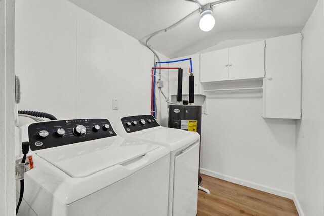 laundry room with water heater, separate washer and dryer, light hardwood / wood-style floors, and cabinets