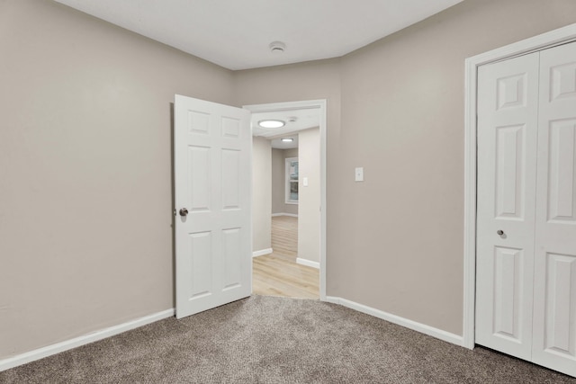 unfurnished bedroom with a closet and carpet flooring