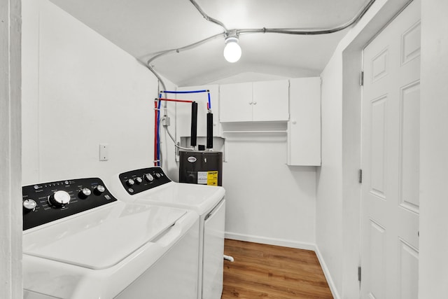 clothes washing area with hardwood / wood-style flooring, separate washer and dryer, cabinets, and water heater