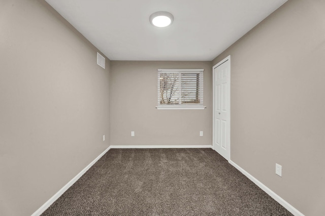 spare room with dark colored carpet