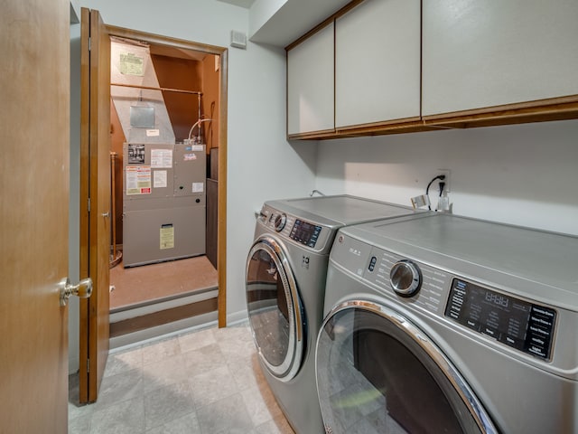 laundry area with cabinets, heating unit, and independent washer and dryer