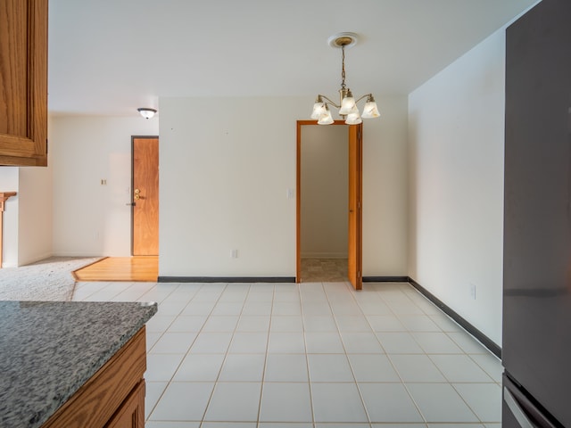 tiled dining space with a notable chandelier