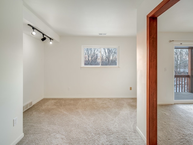 spare room with light colored carpet and track lighting