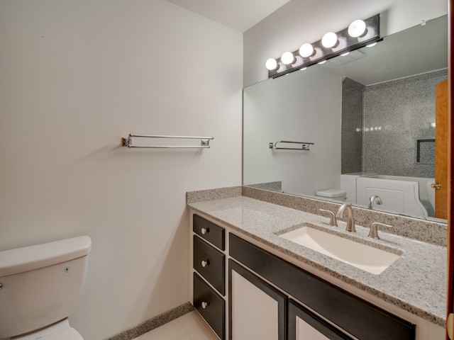 bathroom with toilet, vanity, and tile patterned flooring