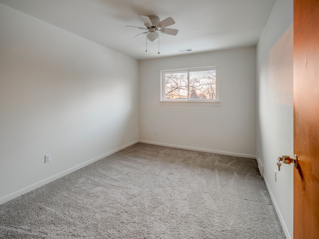 carpeted spare room featuring ceiling fan