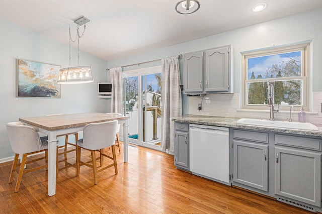 kitchen featuring dishwasher, gray cabinetry, sink, decorative light fixtures, and light hardwood / wood-style flooring