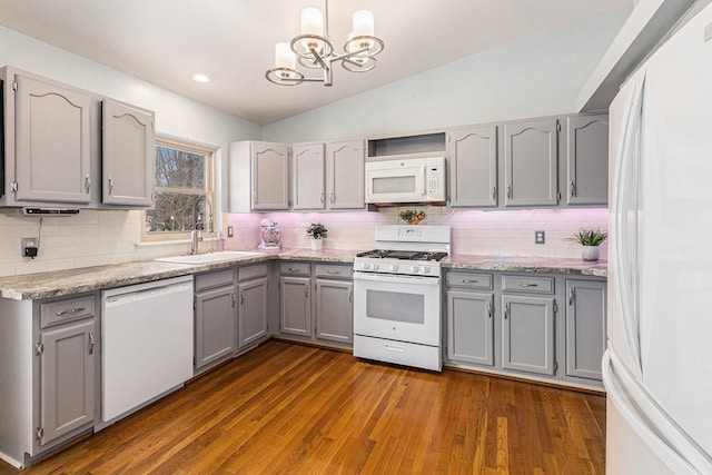 kitchen featuring white appliances, gray cabinetry, sink, dark wood-type flooring, and vaulted ceiling