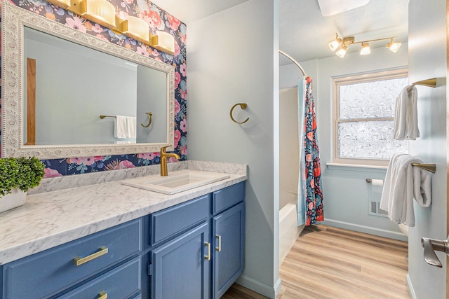 bathroom with hardwood / wood-style flooring, vanity, and shower / bath combo