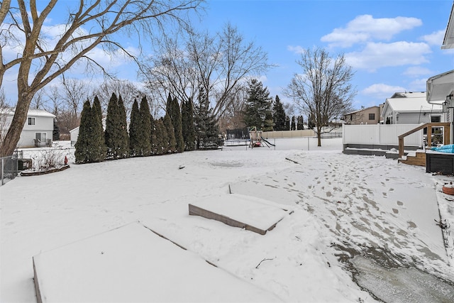 snowy yard featuring a playground