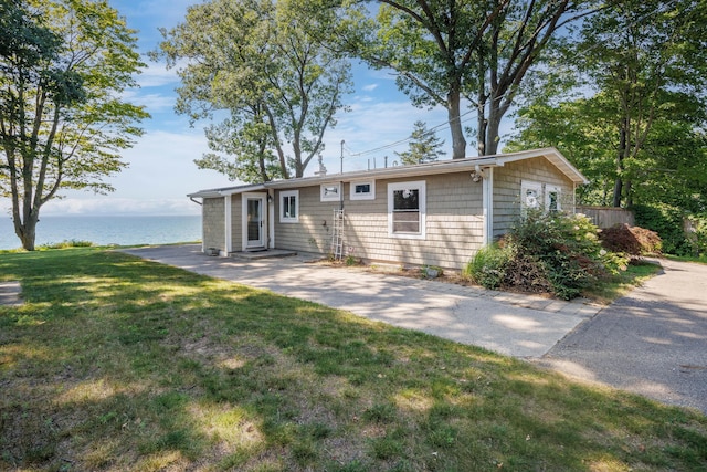 single story home with a water view and a front yard