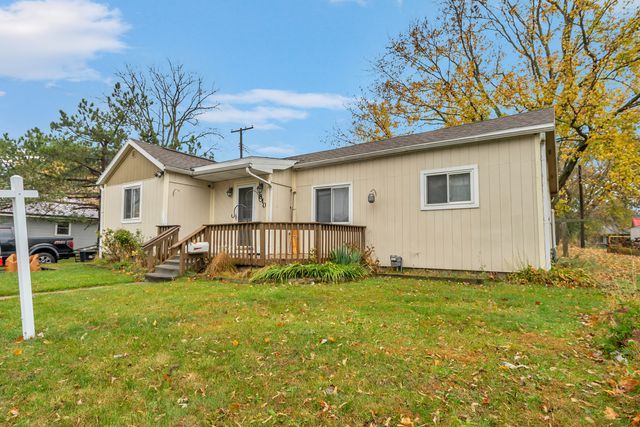 rear view of property with a wooden deck and a lawn