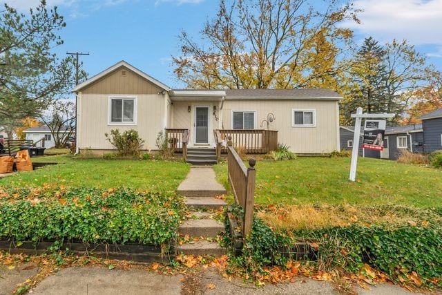 view of front of home with a front lawn and a wooden deck