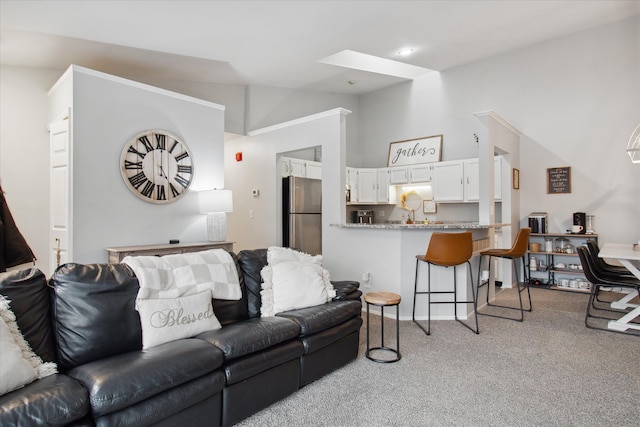 living room with light colored carpet, sink, and lofted ceiling