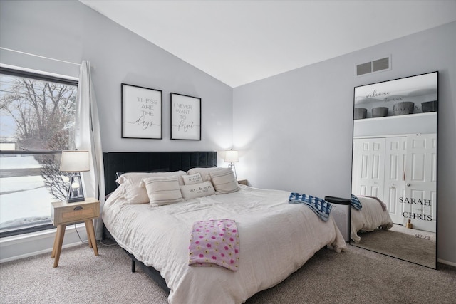 carpeted bedroom featuring a closet and vaulted ceiling