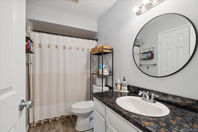 bathroom featuring hardwood / wood-style flooring, toilet, and vanity