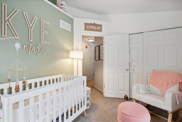 carpeted bedroom with a nursery area, a closet, and vaulted ceiling