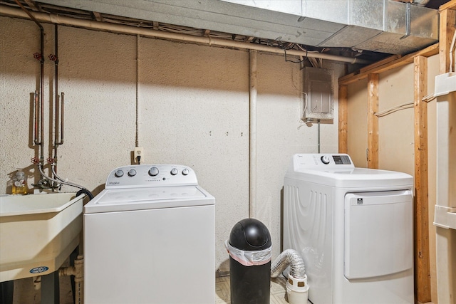 washroom with sink, washer and dryer, and electric panel