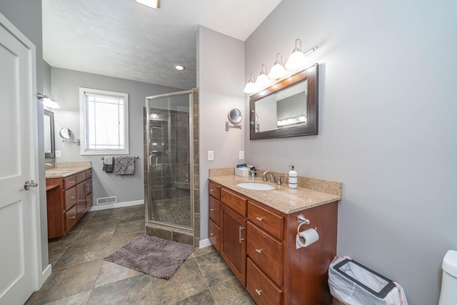 bathroom with a shower with door and vanity