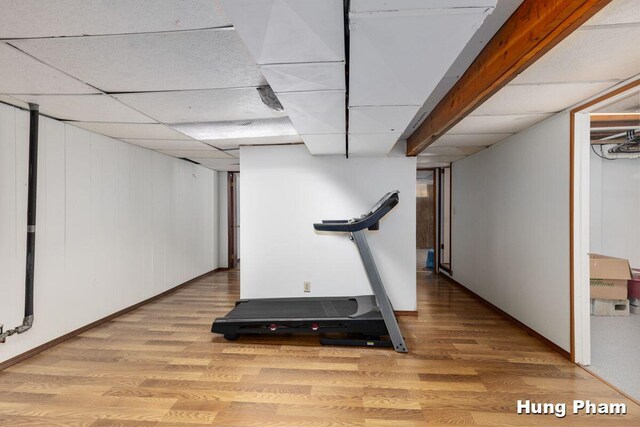 workout area featuring a paneled ceiling and hardwood / wood-style flooring