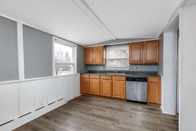 kitchen with sink, vaulted ceiling with beams, baseboard heating, dishwasher, and light hardwood / wood-style floors