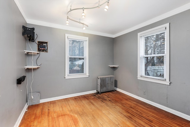 unfurnished room with radiator, ornamental molding, and a healthy amount of sunlight