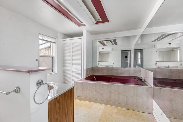 bathroom with a relaxing tiled tub and vanity