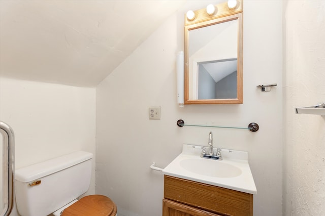 bathroom featuring lofted ceiling, vanity, and toilet