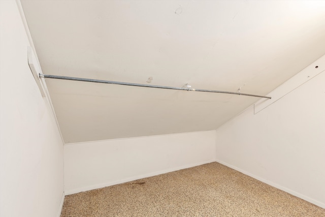 walk in closet featuring vaulted ceiling and light carpet