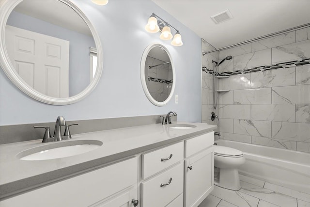 full bathroom with vanity, tiled shower / bath combo, and toilet