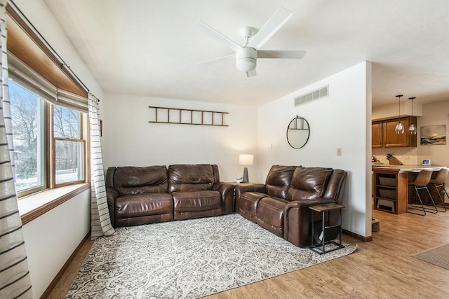 living room with ceiling fan and light hardwood / wood-style floors