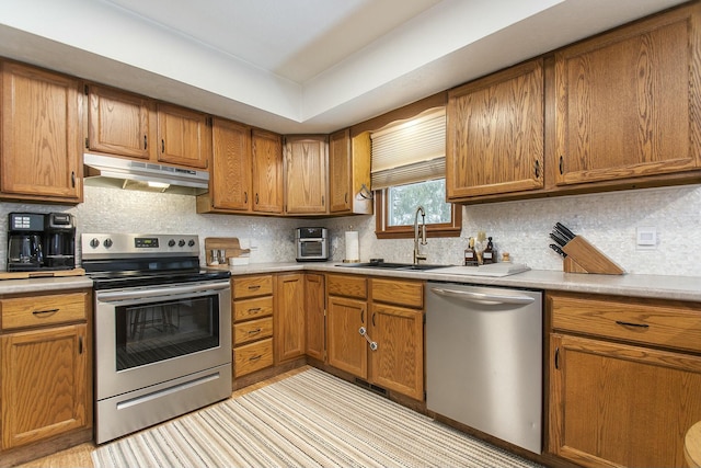 kitchen with sink, backsplash, and appliances with stainless steel finishes