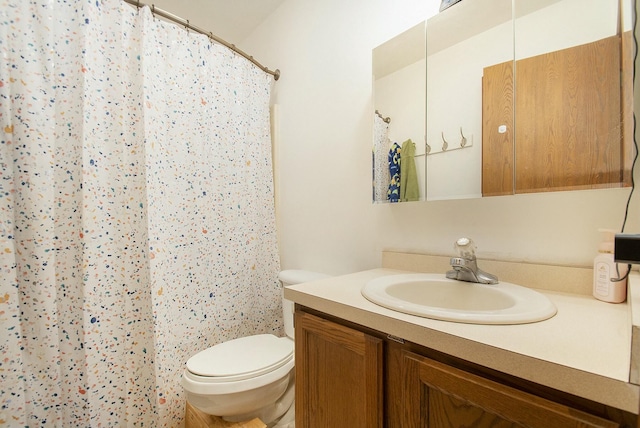 bathroom featuring toilet, a shower with shower curtain, and vanity