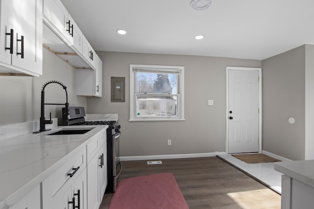 kitchen featuring light stone countertops, white cabinets, dark wood-type flooring, electric panel, and stainless steel range with gas stovetop