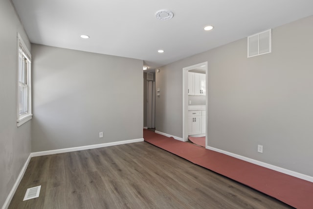 unfurnished bedroom featuring connected bathroom and hardwood / wood-style flooring