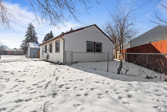 view of snow covered back of property