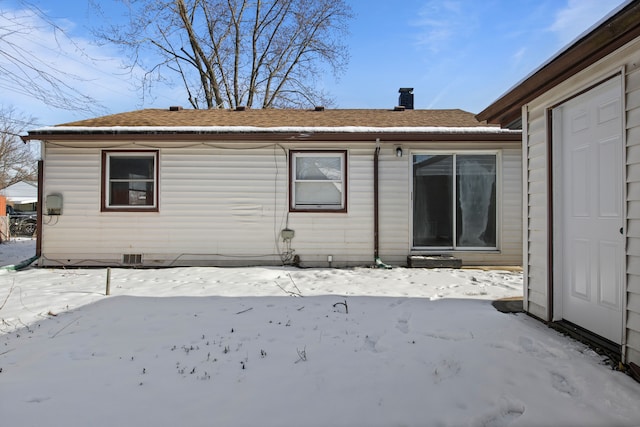 view of snow covered back of property