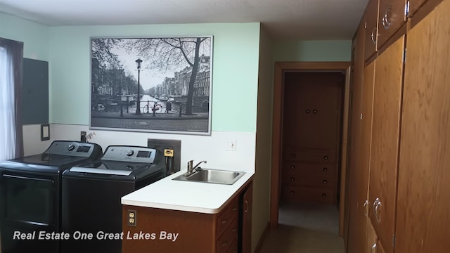 clothes washing area with independent washer and dryer and sink