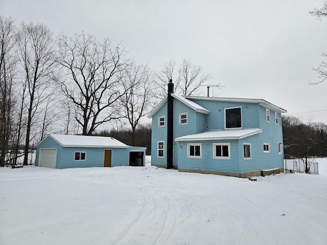 view of front of property featuring a detached garage, a chimney, and an outdoor structure
