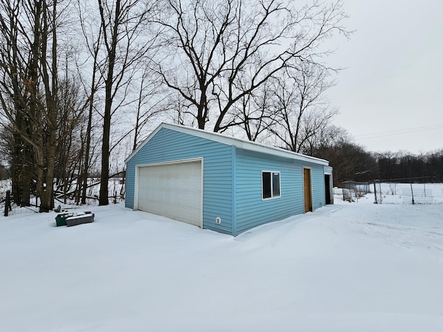 snow covered garage with a detached garage