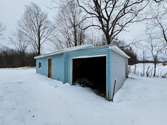 snow covered garage featuring a garage