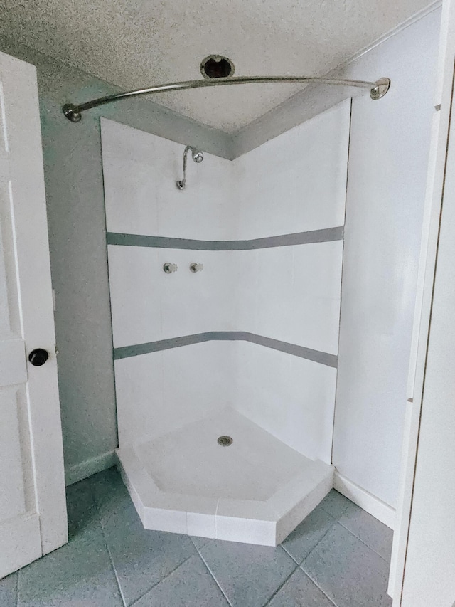 bathroom featuring a shower stall, tile patterned flooring, and baseboards