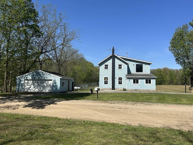 view of side of home with a detached garage, an outbuilding, and dirt driveway