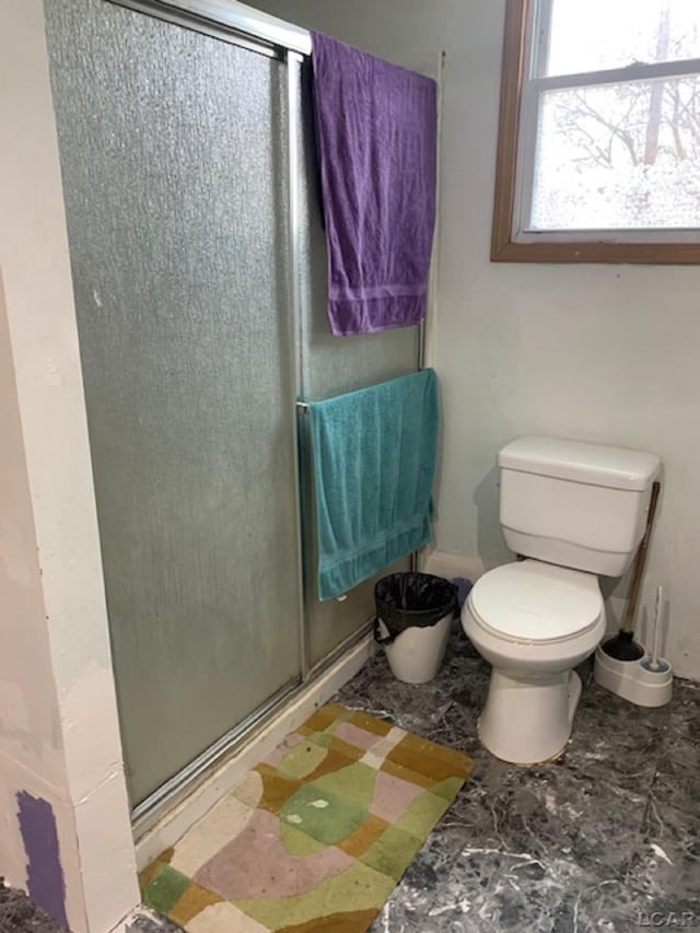 bathroom featuring an enclosed shower and toilet