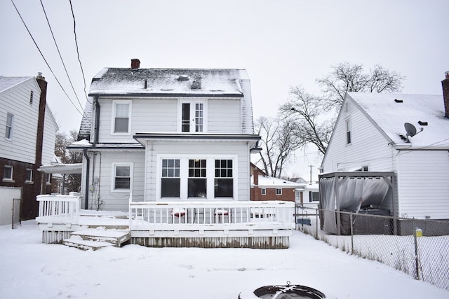 snow covered house featuring a deck and a fire pit