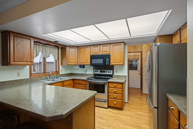 kitchen featuring sink, light hardwood / wood-style flooring, stainless steel appliances, and kitchen peninsula