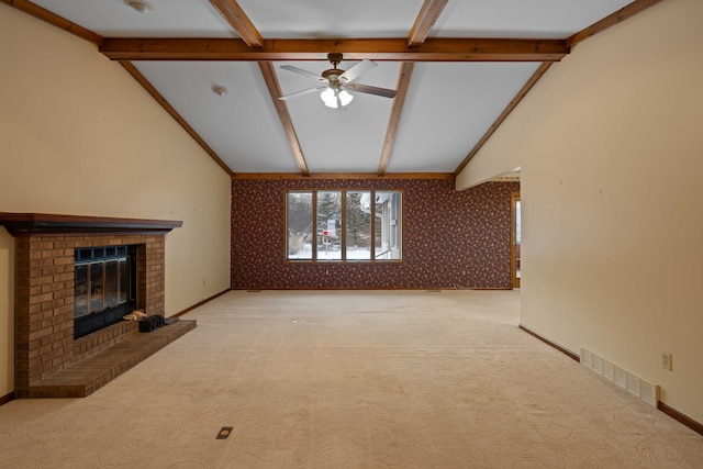 unfurnished living room featuring light carpet, vaulted ceiling with beams, a fireplace, and ceiling fan