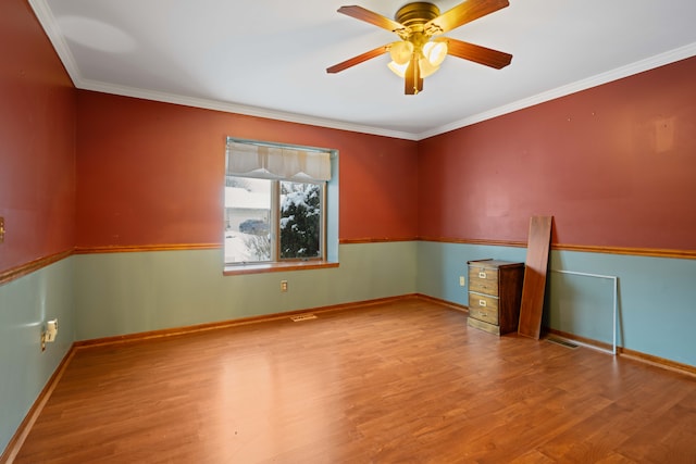 empty room with crown molding, hardwood / wood-style floors, and ceiling fan