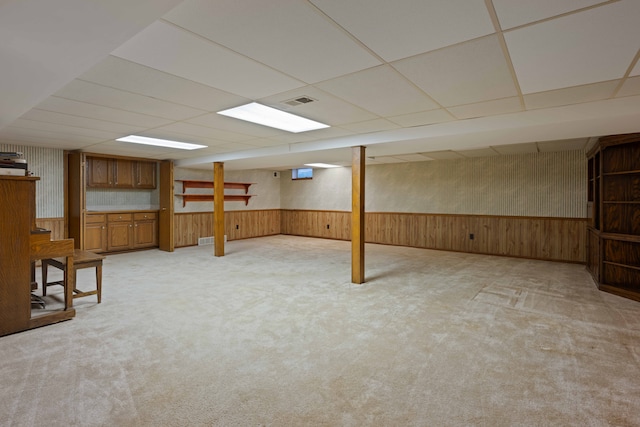 basement with light colored carpet and a drop ceiling